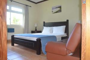 普拉兰大安塞区巴特弗莱别墅酒店的一间卧室配有一张床、一张沙发和一个窗口