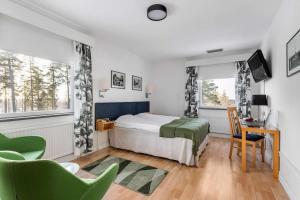 MalmköpingHotel Malmkoping; Sure Hotel Collection by Best Western的一间卧室配有一张床、一张书桌和两个窗户。