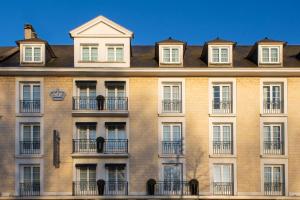 凯恩Best Western Royal Hotel Caen的一座大型砖砌建筑,设有窗户