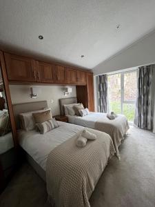 特劳特贝克Lowena Lodge的一间卧室配有两张带毛巾的床