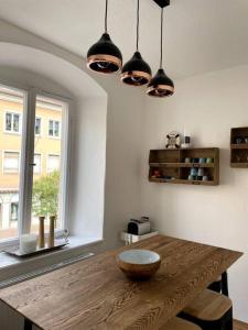 班贝格Penthouse Wohnung in 1A City-Lage in Bamberg的一间带木桌和灯的用餐室