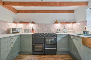 西卢港Cosy Bake Cottage, Great Location in Looe, Cornwall的厨房配有蓝色橱柜和炉灶。
