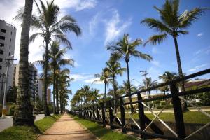 圣劳伦斯海滨Riviera Modulo 6 100m da praia - ATENÇÃO - Piscina em reforma的一条种有棕榈树和围栏的小径