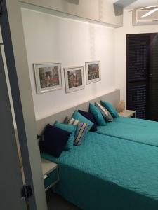 圣劳伦斯海滨Riviera Modulo 6 100m da praia - ATENÇÃO - Piscina em reforma的一间卧室配有带枕头的绿色床