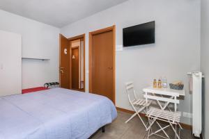 贝加莫伊尔菲欧雷住宅酒店的一间卧室配有一张床、一张书桌和一台电视。