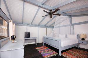 Conch Beach Cabins的卧室配有白色的床和吊扇