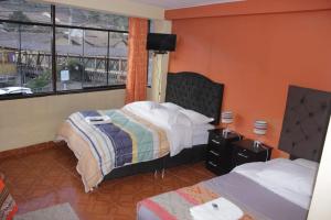 奥兰太坦波hostal Qorisonqo inn ollantaytambo的酒店客房设有两张床和窗户。
