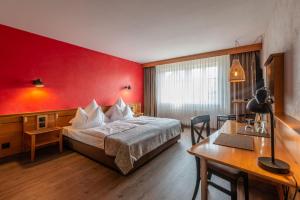 伊普霍芬Biobausewein WEIN HOTEL LEBEN的酒店客房,设有一张红色墙壁的床
