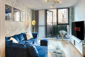曼彻斯特City Centre Apartment - Ideal for longer stays的客厅配有蓝色的沙发和电视