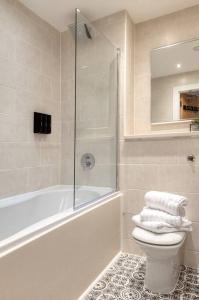 曼彻斯特City Centre Apartment - Ideal for longer stays的带浴缸、卫生间和淋浴的浴室。