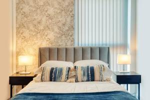 曼彻斯特City Centre Apartment - Ideal for longer stays的一间卧室配有一张带两张台灯的床铺。