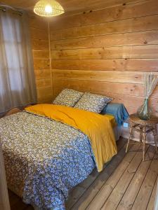 TrémontLA CABANE DE JABI的一间卧室配有一张木墙床