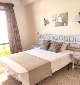 罗列特海岸圣安娜旅舍的卧室设有一张白色大床和一扇窗户。