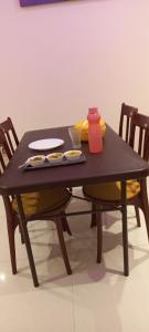布莱尔港Pibo Homestay的一张桌子和两把椅子,上面有盘子和花瓶