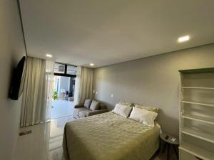 巴拉那州蓬塔尔Pousada Guaricana的一间卧室设有一张床和一间客厅。