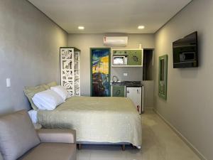 巴拉那州蓬塔尔Pousada Guaricana的一间卧室配有一张床和一个沙发