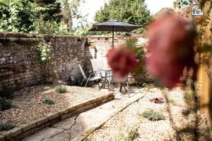 萨弗伦沃尔登Braybrooke Cottage, Saffron Walden的一个带桌子和遮阳伞的花园