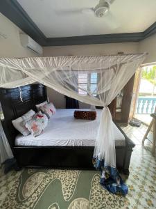 Kiembi SamakiAnayah House的一间卧室配有一张带天蓬的床