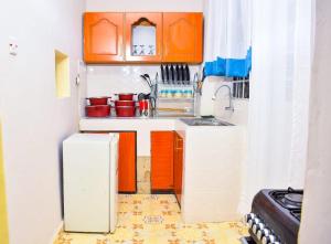 基苏木Lux Suites 1 Bedroom Okore Estate Apartment Kisumu的小厨房配有橙色橱柜和冰箱