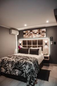内尔斯普雷特Cascades Guest Lodge的一间卧室设有一张大床和一张带照片的墙壁