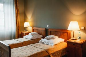 Wojanów帕拉斯沃间诺酒店的一间卧室配有两张床和一盏灯