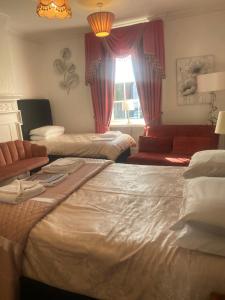 布里奇诺斯Parlors Hall Hotel的客房设有两张床、一张沙发和一个窗口。