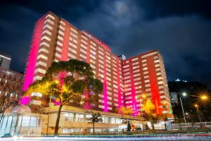 波哥大GHL Hotel Tequendama Bogotá的一座酒店大楼,上面有粉红色的灯光