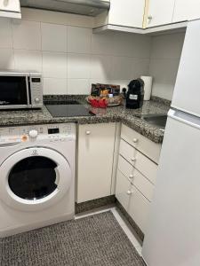 塞维利亚Apartamento Fibes-Congresos Parking Gratis的厨房配有洗衣机和微波炉。