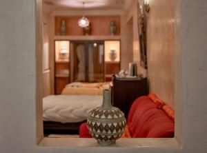 瓦尔扎扎特Riad Tama & spa的一间房间,在架子上设有床和花瓶