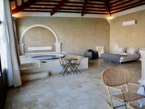 VentabrenLe Pool House - Private Jacuzzi - Mas des Sous Bois的一间带浴缸和桌椅的客厅