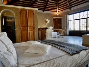 VentabrenLe Pool House - Private Jacuzzi - Mas des Sous Bois的卧室配有一张带两个枕头的大白色床