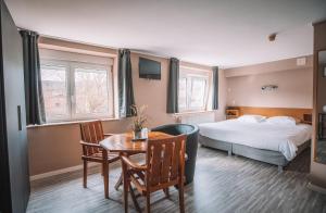 小勒尚乐米迪酒店的酒店客房带一张床、一张桌子和椅子