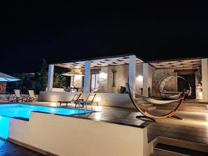 罗希姆诺Kallixeni Villas的夜间带游泳池的别墅