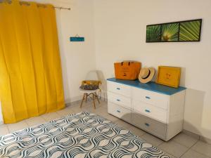 Oyster PondPERLE DES ANTILLES的一间卧室配有梳妆台和黄色窗帘