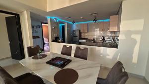 阿布扎比Prestigeo Guest House Abu Dhabi的厨房以及带桌椅的用餐室。