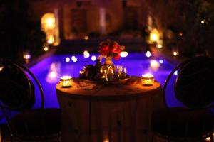 瓦尔扎扎特Riad Tama & spa的一张带蜡烛的桌子和一个花瓶