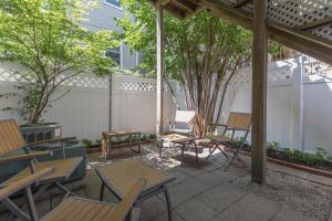 波士顿Sunny convenient home w/ private patio! Easy walk to everything!的庭院设有木桌、椅子和树木