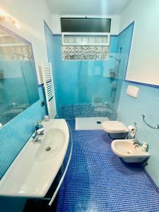 巴里HomeClass的蓝色的浴室设有水槽、浴缸和卫生间。