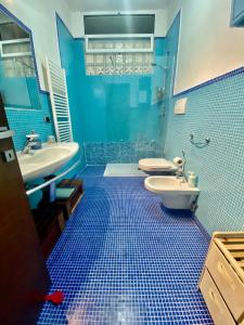 巴里HomeClass的蓝色瓷砖浴室设有卫生间和水槽