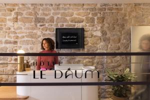 巴黎Hôtel Le Daum的一位用鼓声站在桌子后面的女人