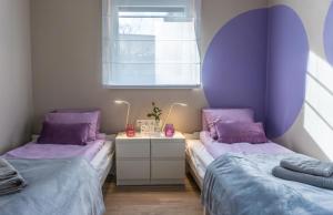 福纽德Babvirág Porta Fonyódliget的紫色枕头间内的两张床