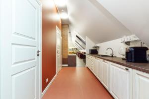 KülitseAida Apartment的一间厨房,配有白色的橱柜和一扇开放式门