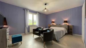 Saint-Jean-le-Vieux祖比亚提亚住宿加早餐旅馆 - 距离孔波斯特拉3公里的一间卧室设有紫色的墙壁、一张床和两把椅子