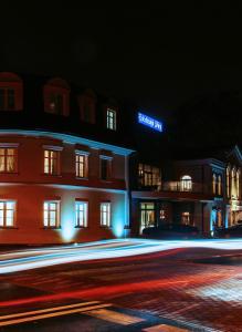 新苏尔Hotel Nadodrzański Dwór - Nowa Sól的街上的一座建筑,晚上有灯