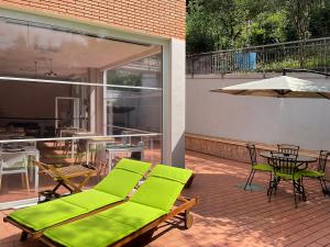 乌尔比诺天堂住宿加早餐旅馆的庭院设有绿色的沙发、桌子和椅子