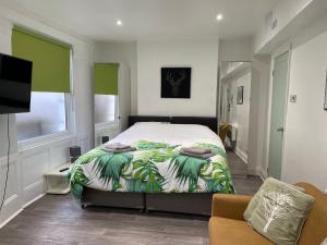 伦敦米尔德梅路公寓的一间卧室配有一张床、一张沙发和一台电视
