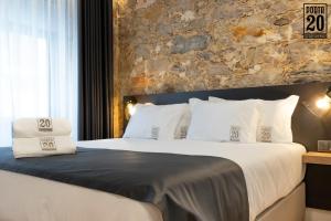 莱里亚Porta 20 Boutique Guesthouse的一间卧室设有一张带石墙的大床