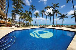 檀香山OUTRIGGER Waikiki Beach Resort的一座棕榈树和海洋游泳池
