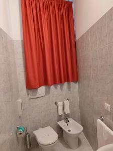 CastelgombertoAlloggio Al Ponte的浴室设有卫生间和红色的淋浴帘