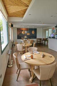 厄尔·波普瑙·德尔·戴尔三角洲拉尔加迪尔酒店的餐厅配有木桌和椅子